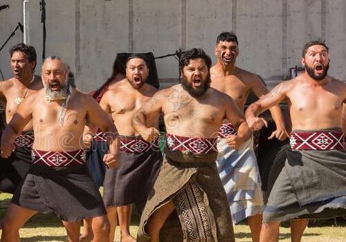 maorimensen-die-een-haka-nieuw-zeeland-uitvoeren-groep-kleedde-zich-traditioneel-kostuum-uitvoerend-bij-onderstel-maunganui-152611383